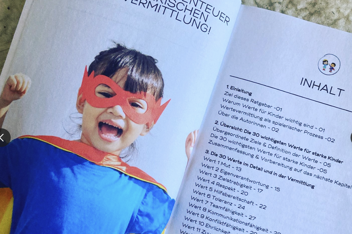 Junge mit Umhang und Sonnenbrille steht vor einem alten Gebäude und schaut zurück.