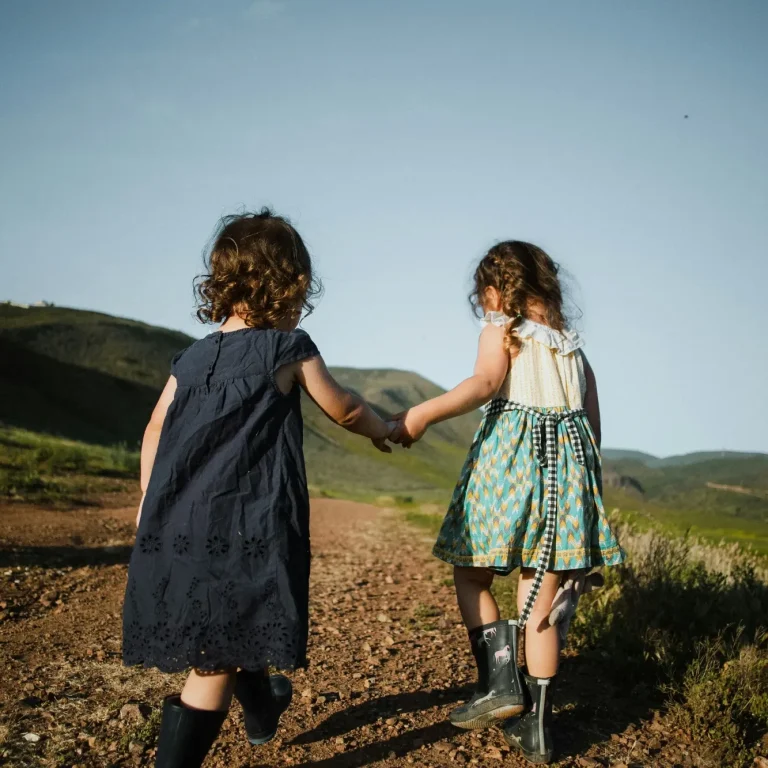 Ein kleiner Junge in einem Superhelden-Kostüm mit Umhang und Sonnenbrille.