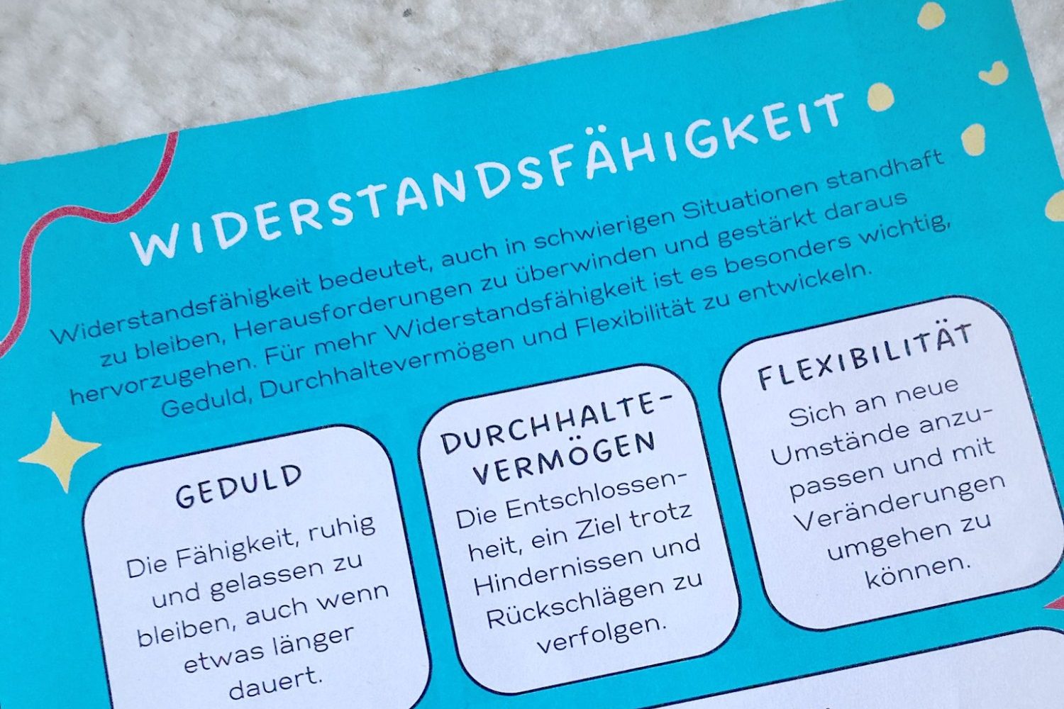 Eine fröhliche Frau sitzt mit fünf Kindern auf einem grauen Sofa.